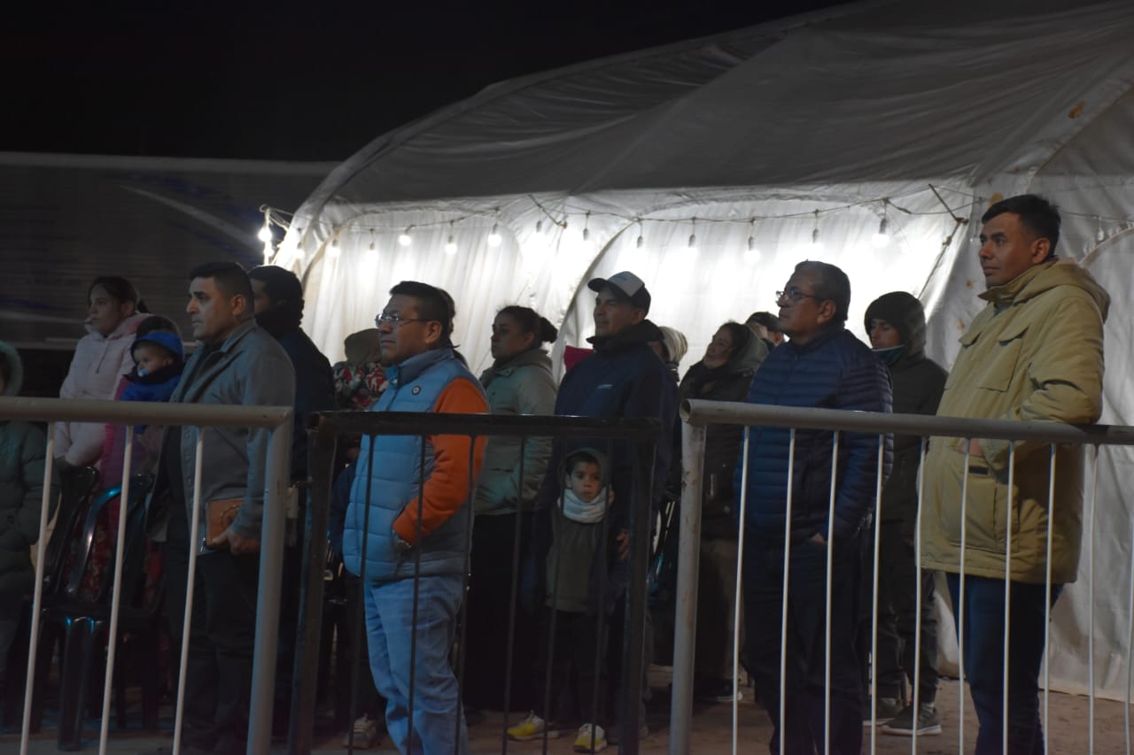 Asistentes de pie junto a la carpa durante la campaña.